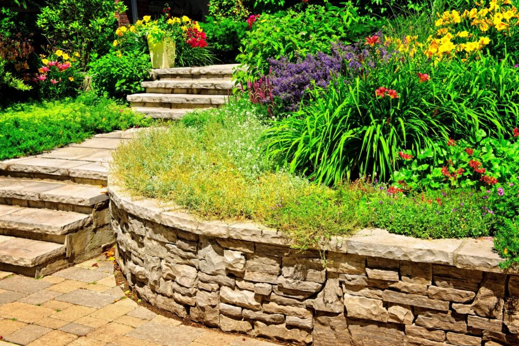 Stone retaining wall with garden landscaping and steps in Denver, NC
